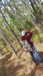 Rear view of woman standing in forest