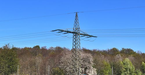 Low angle view of electricity pylon against clear sky