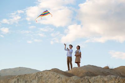 Rear view of people on rock against sky