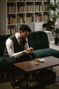 Young man looking at camera while sitting on table