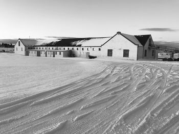 Houses on snow covered land against sky in city