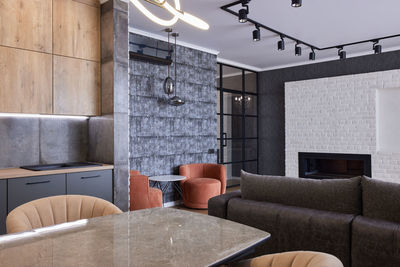 Modern kitchen interior of studio apartment in gray and brown colors and tones. twisted chandeliers.