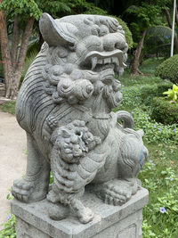 Close-up of old statue against trees