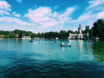 View of boats in lake against cloudy sky