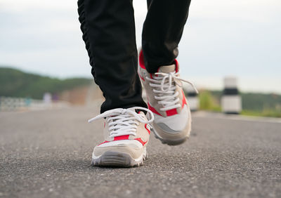 Low section of man walking on road