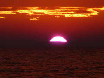 Scenic view of sea against orange sky