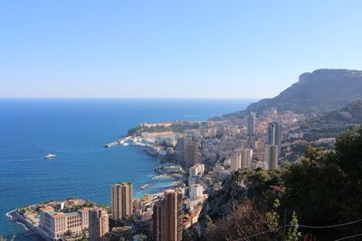 Aerial view of buildings and sea against clear sky