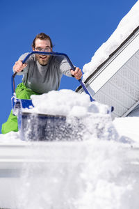 Man holding umbrella standing on snow