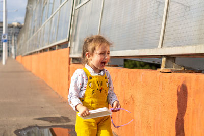 Full length of a boy holding while standing outdoors