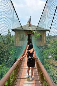 Rear view of woman on footbridge