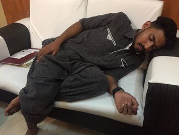 High angle view of man sitting on sofa at home