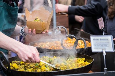 Midsection of man packing food at market stall