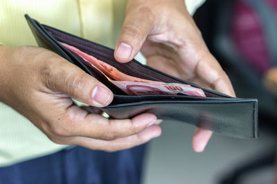 Midsection of man holding wallet