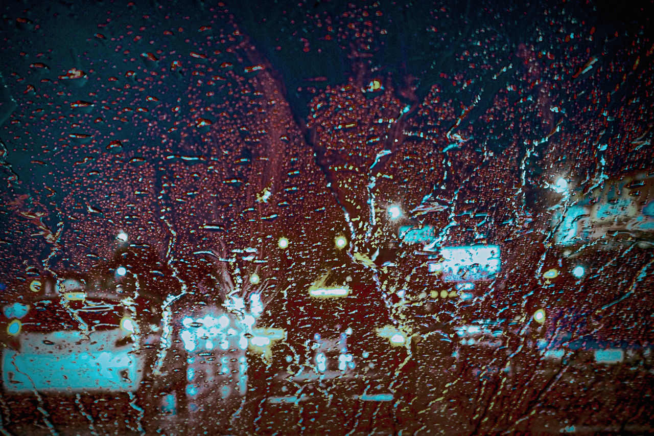 FULL FRAME SHOT OF WET GLASS WINDOW IN RAIN