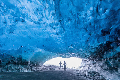 People standing in ice cave