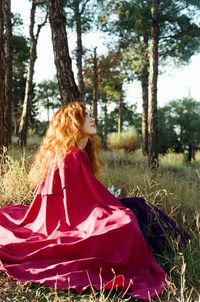 Woman wearing hat on field against trees