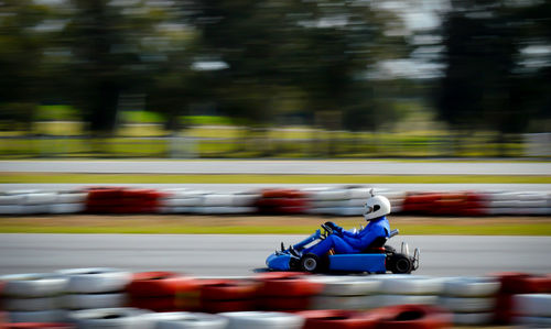 Side view of person driving vehicle during race