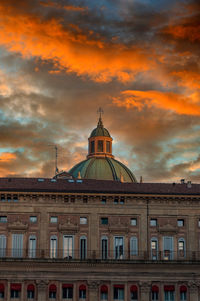 Low angle view of building against cloudy sky during sunset