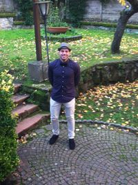 Portrait of young man standing on footpath