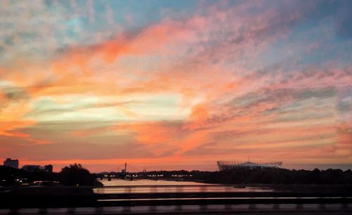 Scenic view of river against dramatic sky during sunset