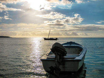 Ship moored on sea against sky during sunset