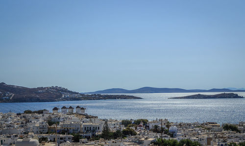 Scenic view of sea by town against clear blue sky