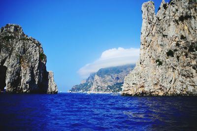 Scenic view of sea and rocky mountains