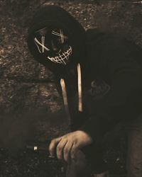 High angle view of man holding camera at night
