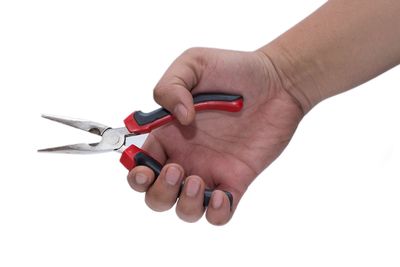 Cropped hand holding work tool against white background