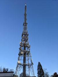 Low angle view of communications tower against clear blue sky