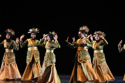 Women wearing costumes dancing on stage