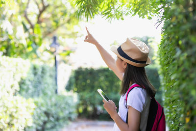 Rear view of woman gesturing while using mobile phone