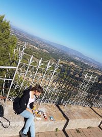 Woman standing against clear blue sky