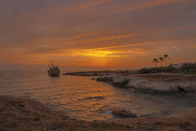 Sun setting over shipwreck of edro iii in sea cave area near paphos, cyprus.