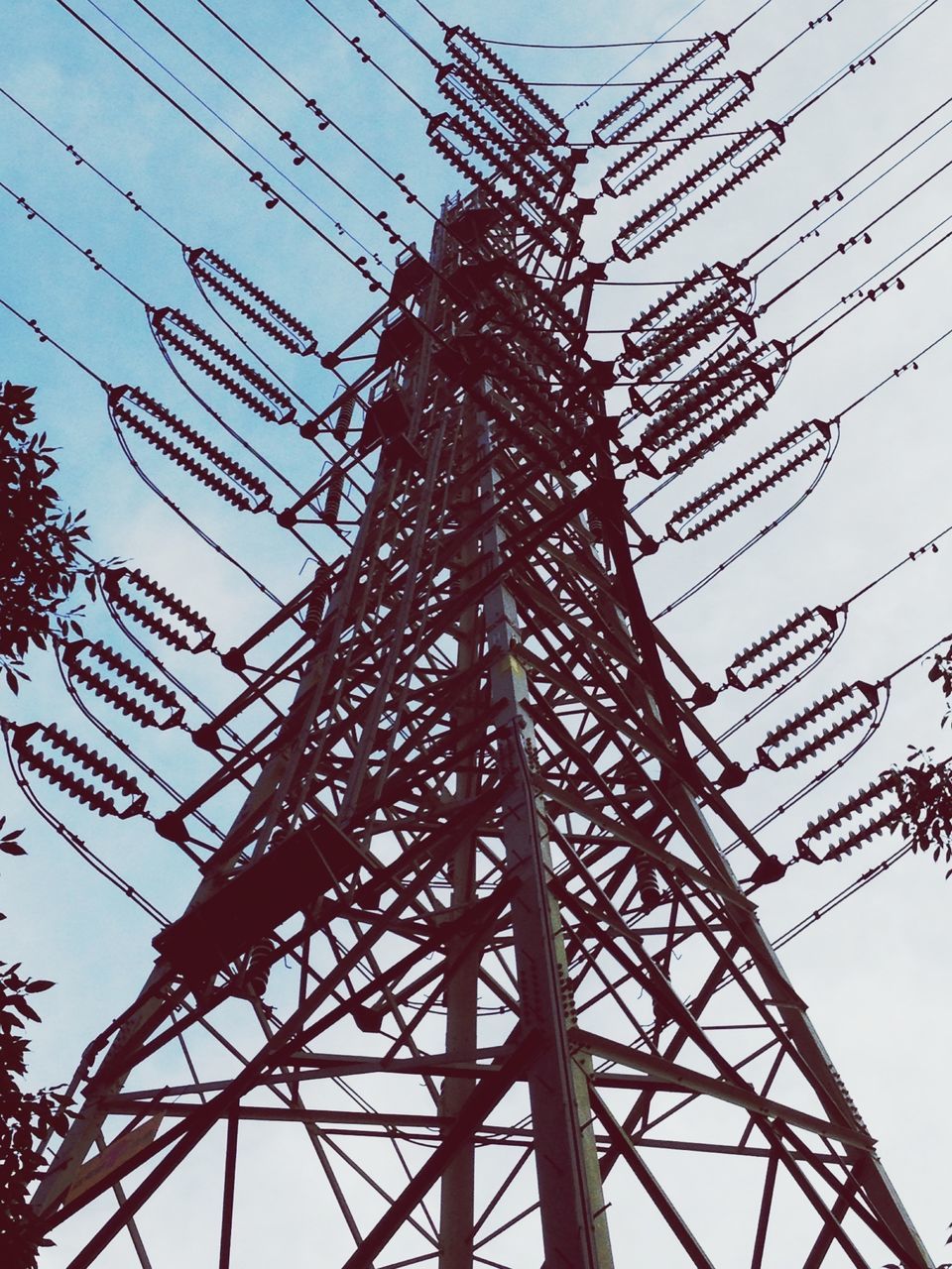 low angle view, connection, electricity pylon, power line, clear sky, power supply, sky, cable, electricity, fuel and power generation, built structure, technology, complexity, metal, tall - high, silhouette, architecture, outdoors, day, no people