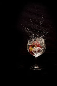 Close-up of wine glass against black background