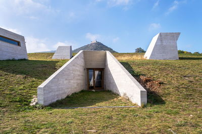 Built structure on field against sky