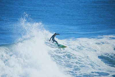 Man surfing on waves in sea