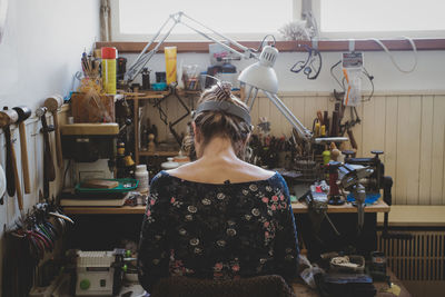 Rear view of woman standing at shop