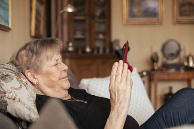 Senior woman on sofa using cell phone