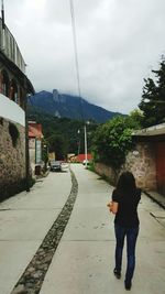 Full length of woman walking on road against sky