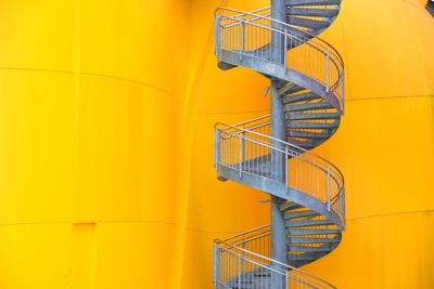 Spiral staircase against yellow wall