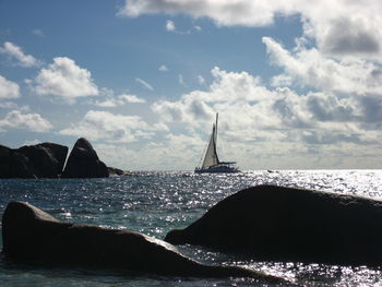 Sailboat sailing on sea against sky