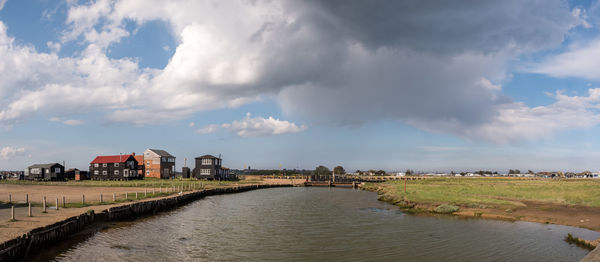 Panoramic view of river by buildings against sky