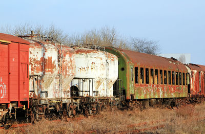 Old abandoned freight trains against clear sky