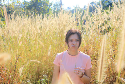 Portrait of young woman standing on field