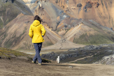 Young woman is admiring iceland's foreign volcanic landscape