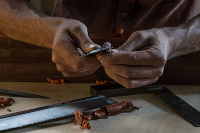 Close-up of midsection of carpenter sharpening pencil