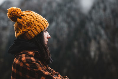 Side view of young woman looking away outdoors