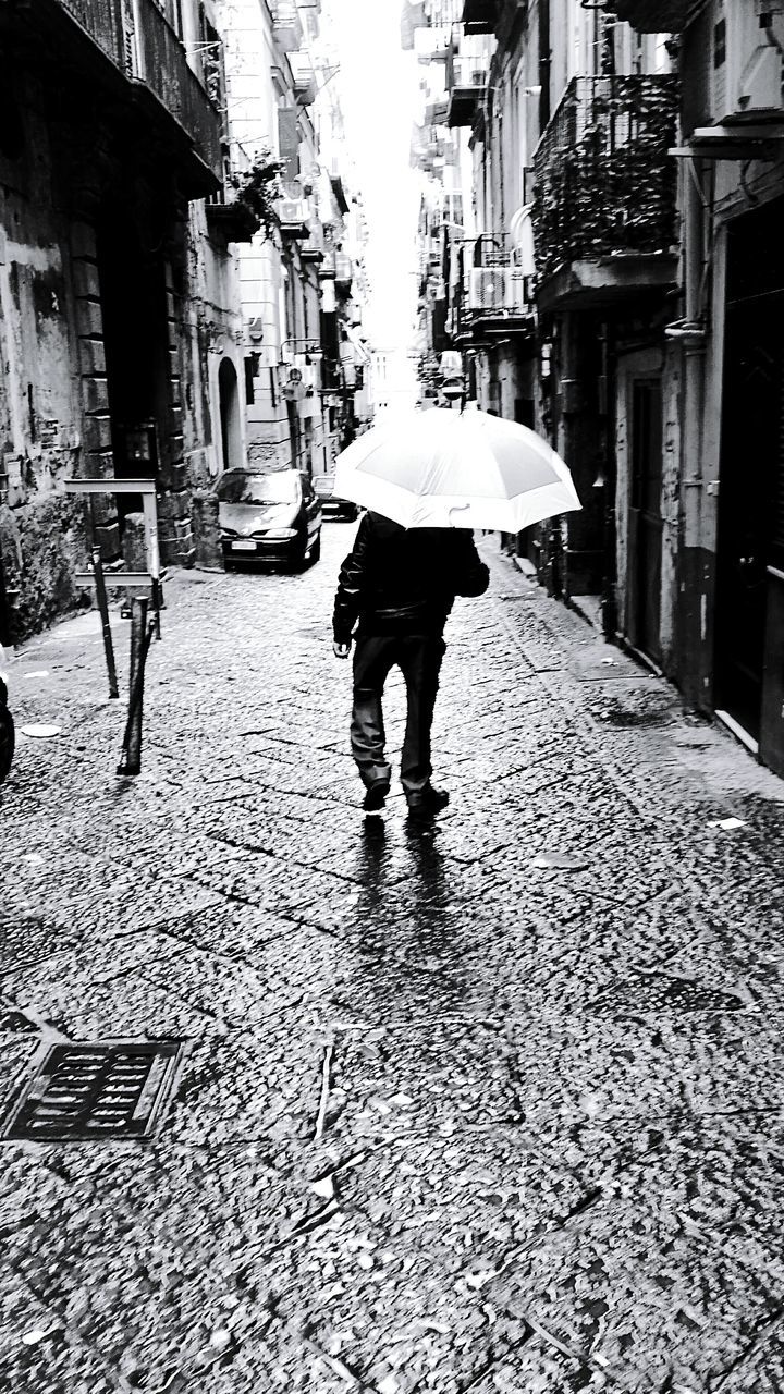 MAN STANDING ON WET STREET